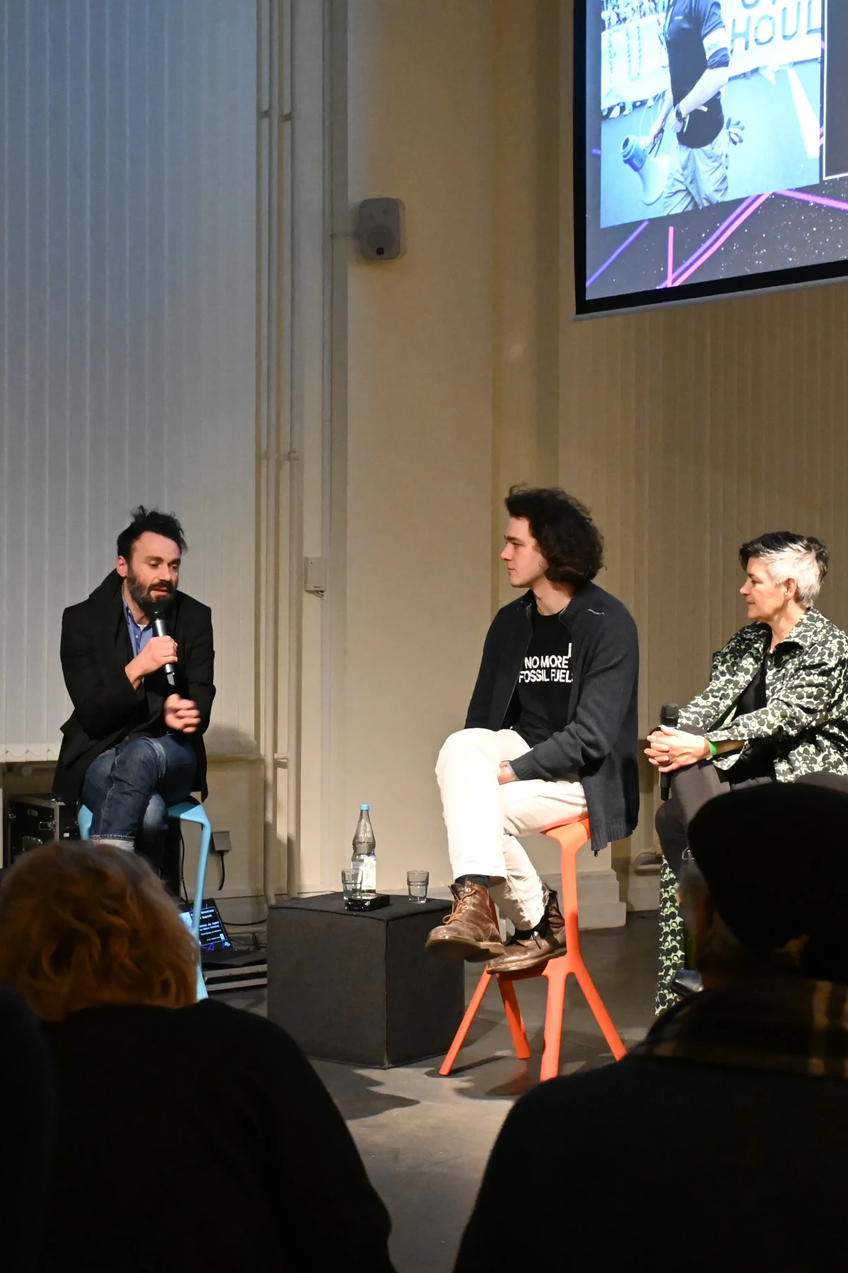 Vier Menschen sitzen auf Stühlen und diskutieren miteinander.