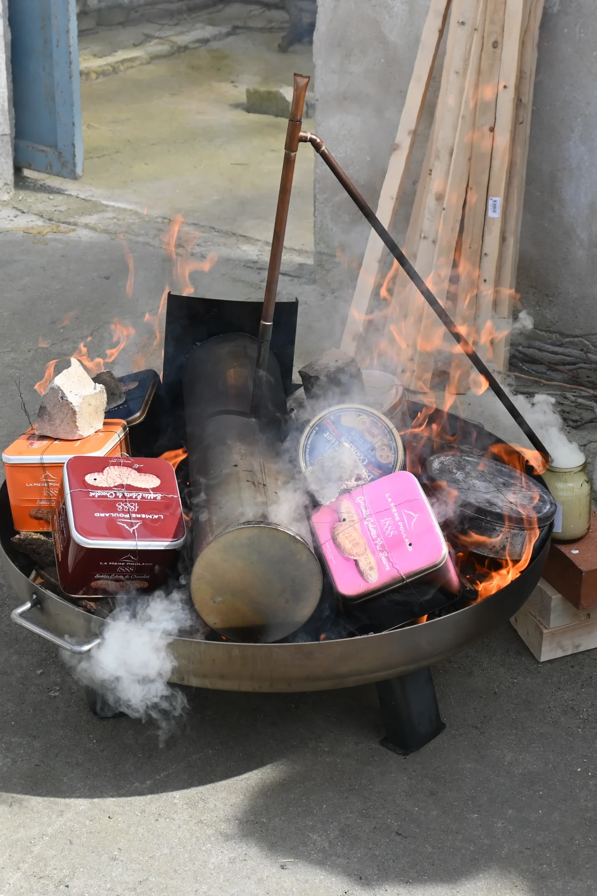 Feuerschale mit Metallboxen im Feuer beim Köhler-Prozess
